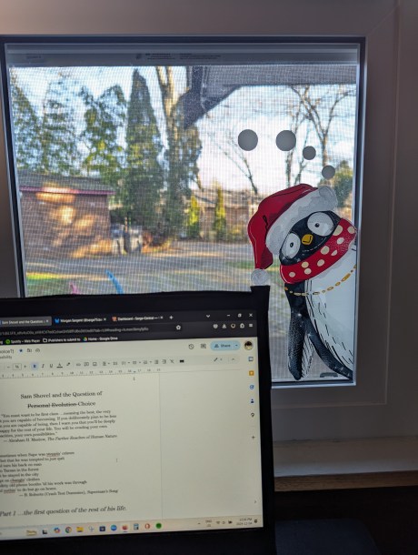 A cartoon penguin on a window pain look over the edge of a laptop screen that contains some writing